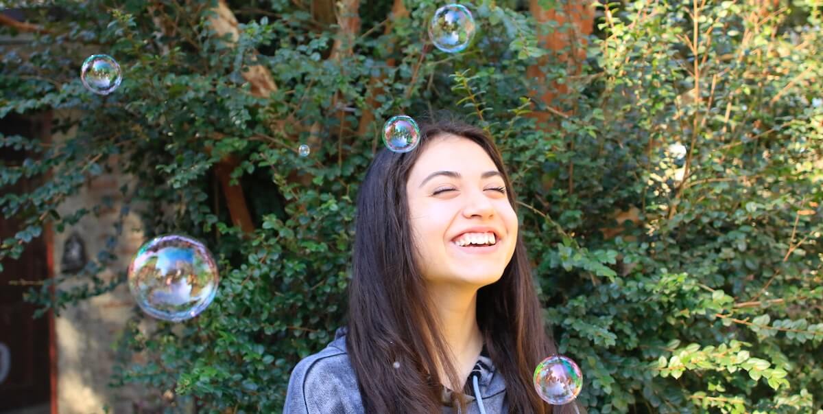 fille heureuse jouant avec des bulles dans le jardin