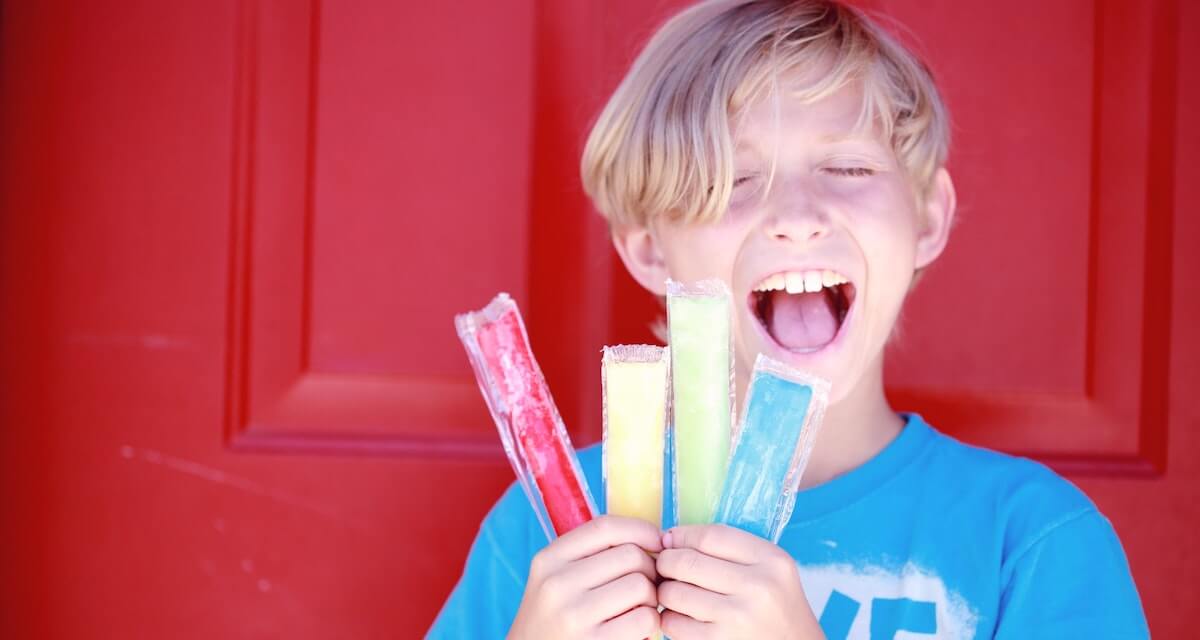 Ein Junge isst ein Eis am Stiel