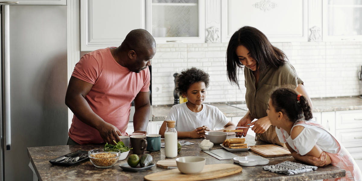 familia feliz preparando una comida saludable en la cocina