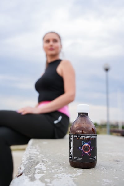 mujer con una botella de glutatión